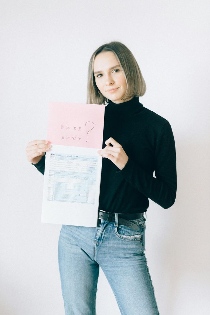 Young woman with paperwork holding tax forms and question sheet.